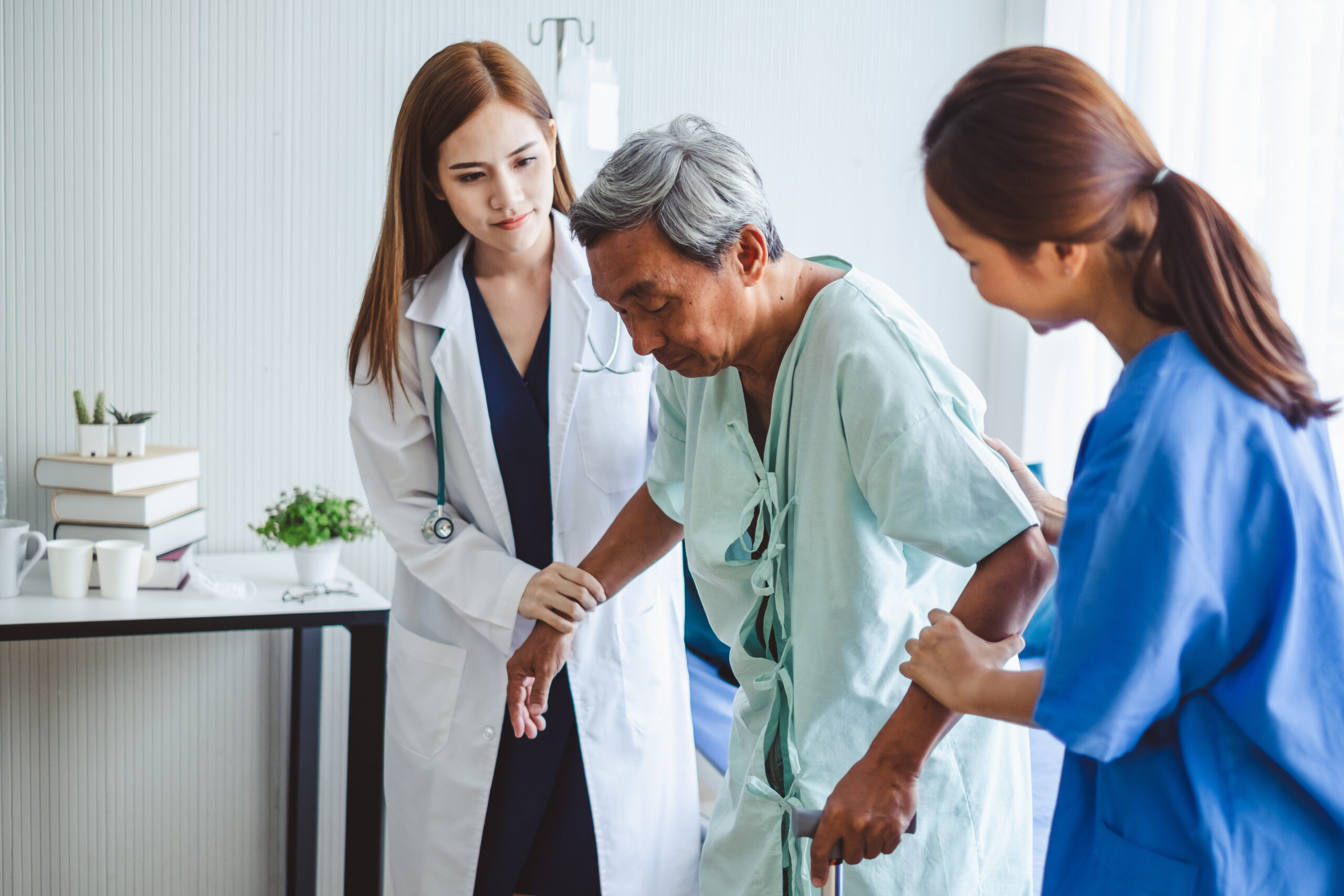 Asian doctor woman and nurse encourage disabled old man patient