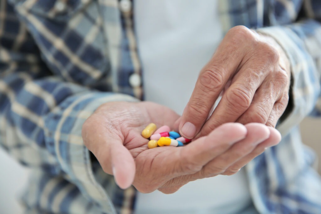 Senior man taking pills, closeup