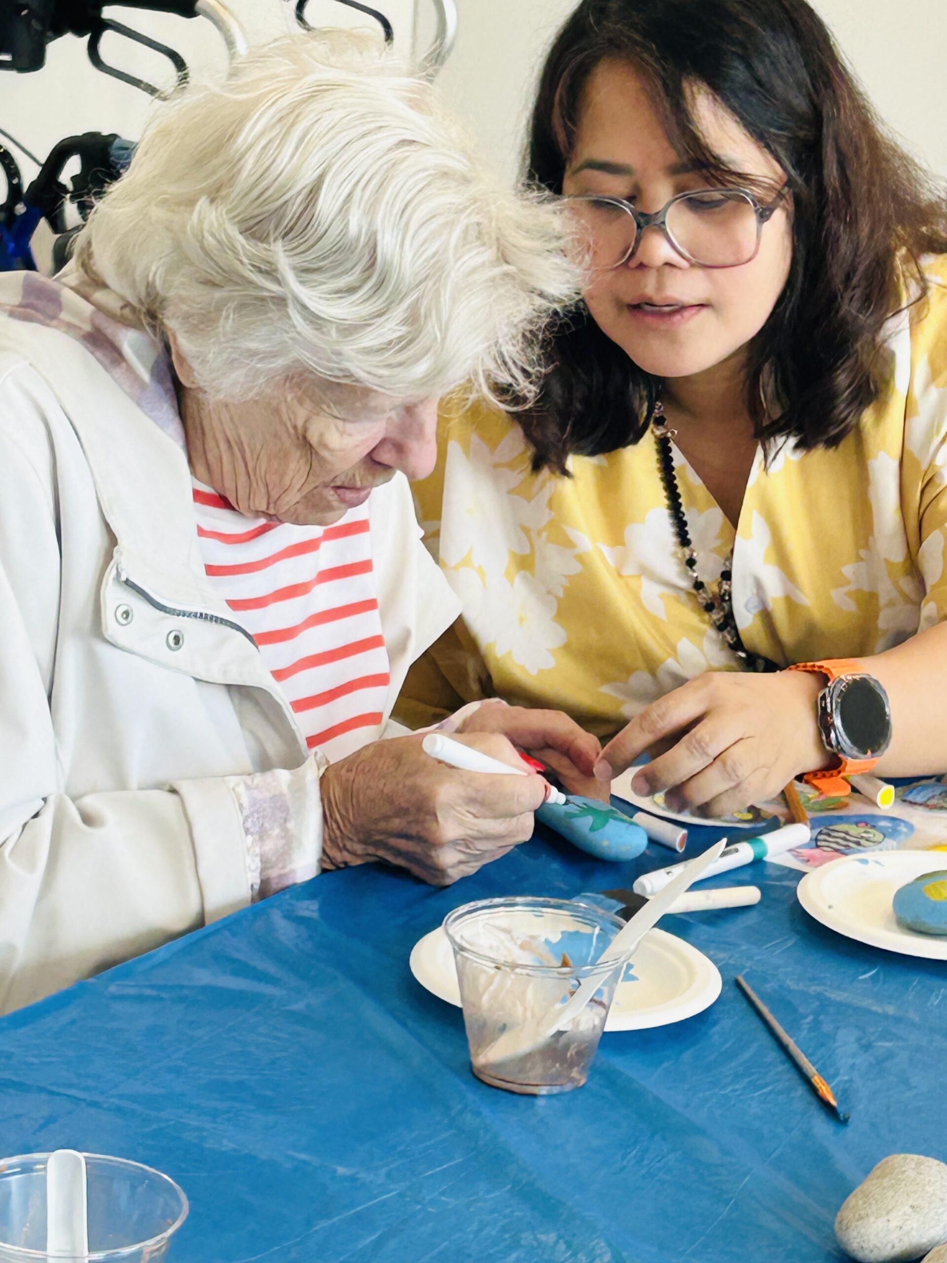 Resident working on an arts and crafts project with fellow residents and care teams