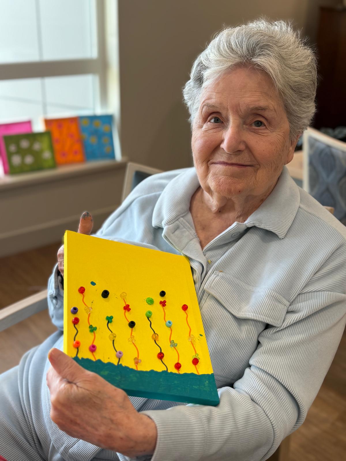 resident and arts Bayview resident proudly showing a colourful art project during a creative activity in White Rock